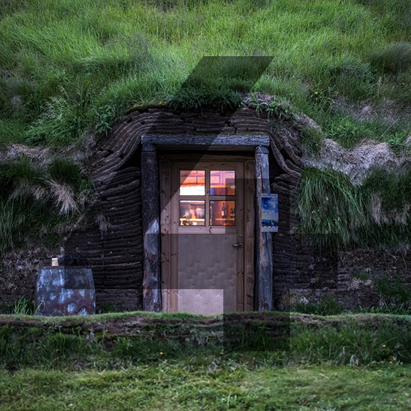 A house built into the side of a hill made out of a wooden door with a window